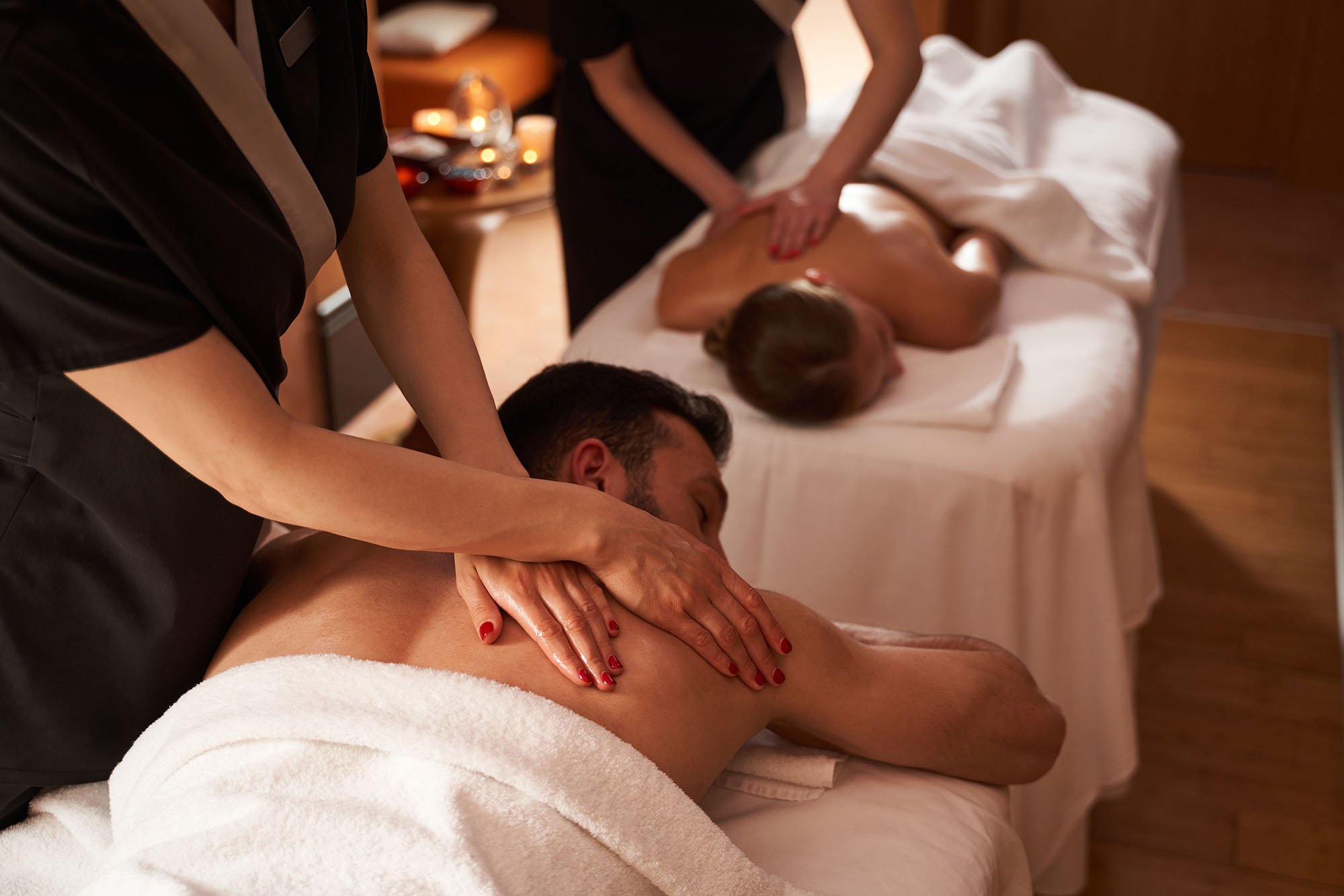 Simultaneous massage for two young people in spa salon